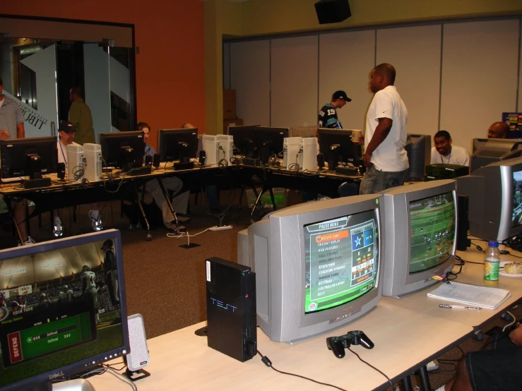 men standing around tables playing a game with their wii motes