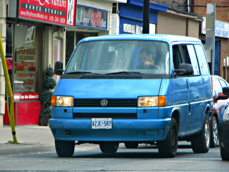 two cars sitting next to each other in front of shops