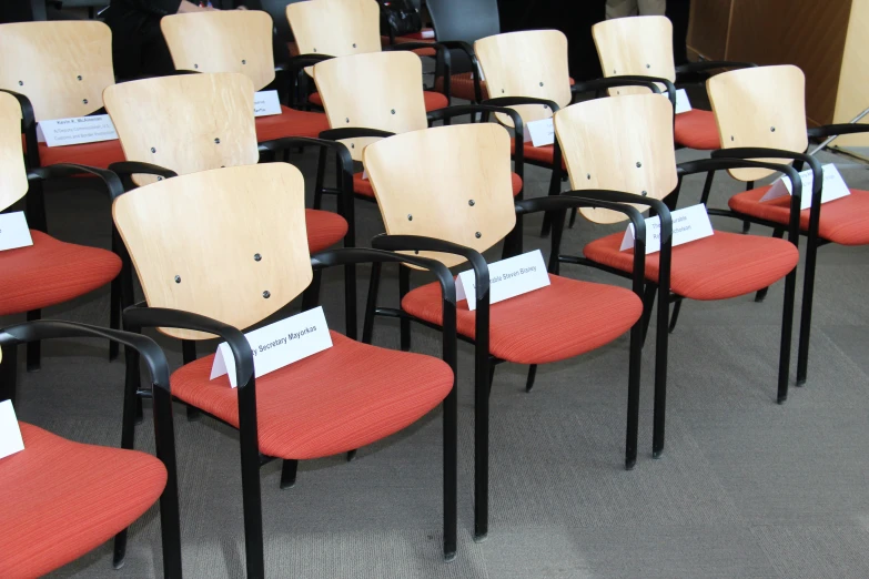 chairs with red chairs with black seats and some tags on them