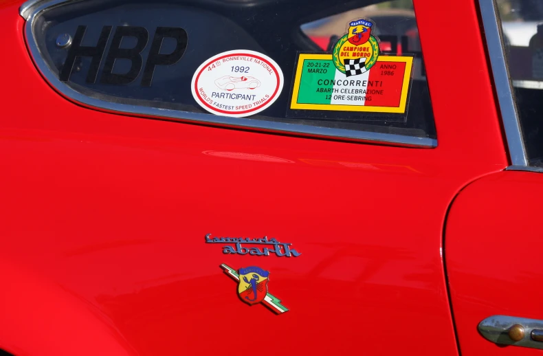 stickers and logos on the side of a red car