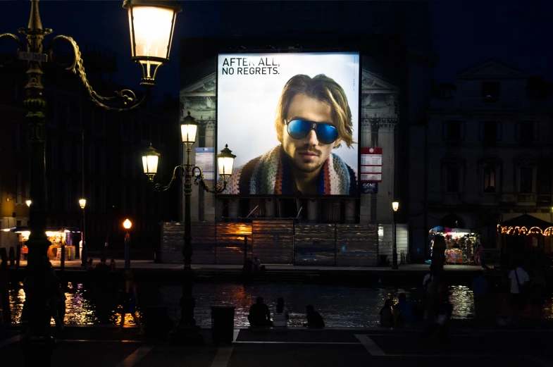 a large lighted billboard next to a river