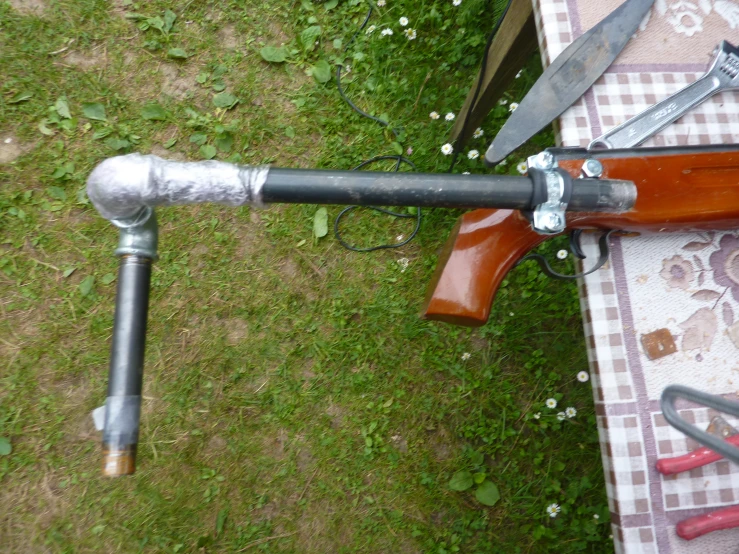 an automatic rifle that has a bullet in the center is sitting on a picnic table