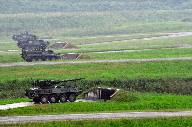 a couple of military vehicles are in the rain