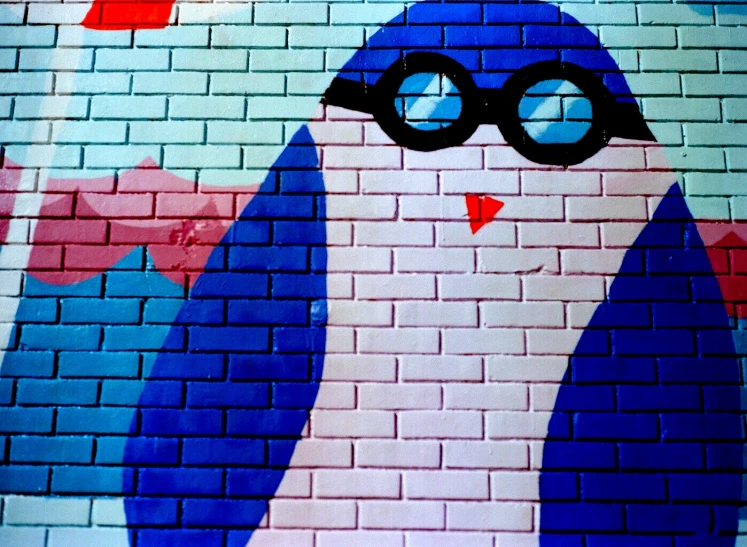 an image of a blue bird painted on a brick wall