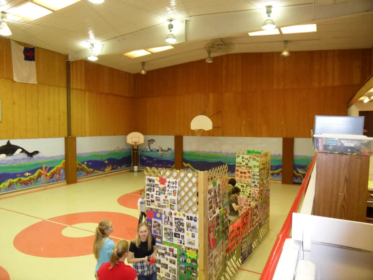 two children look at a display in a school gym