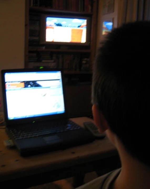 a child is playing video games on the laptop