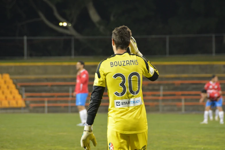 a soccer player in yellow stands on a field