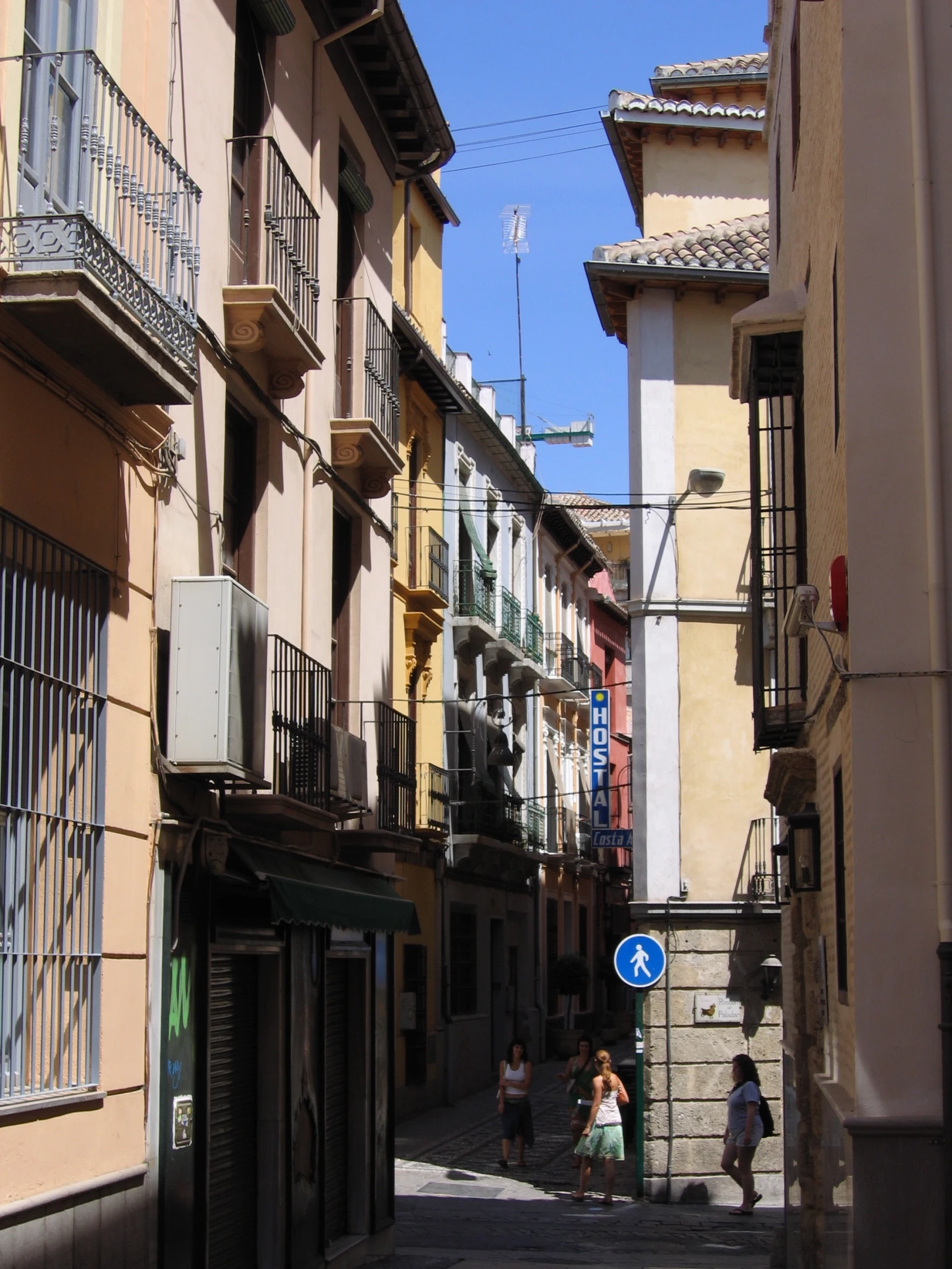 people in the middle of a street lined with buildings