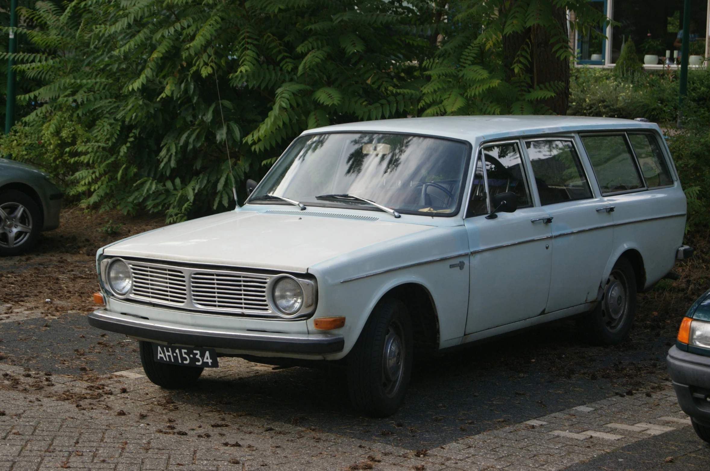 this is an old station wagon parked in front of some other cars