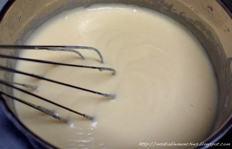 a metal bowl with three attachments filled with batter