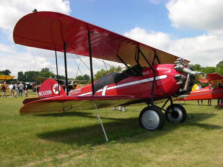 a small red airplane that is in the grass