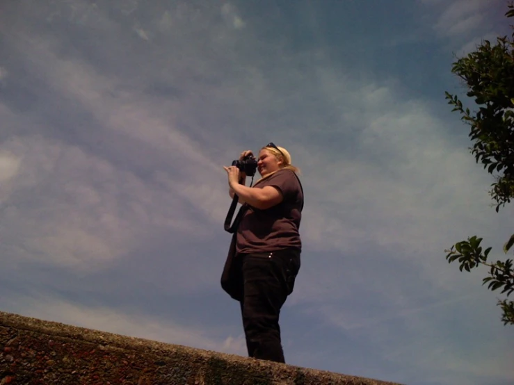 a man on a roof taking pictures with his phone