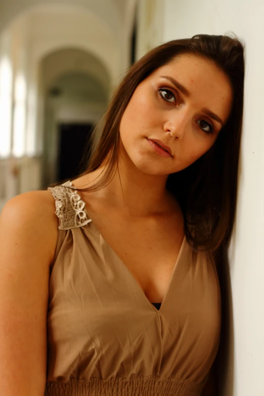 a woman leaning against a wall with her arms on the other side