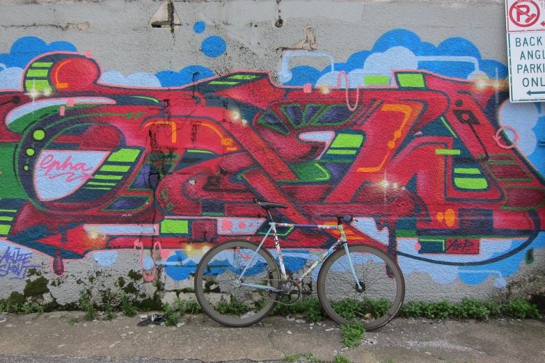 a bike against a wall with graffiti on it