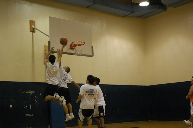 two teams of men playing basketball on an indoor court