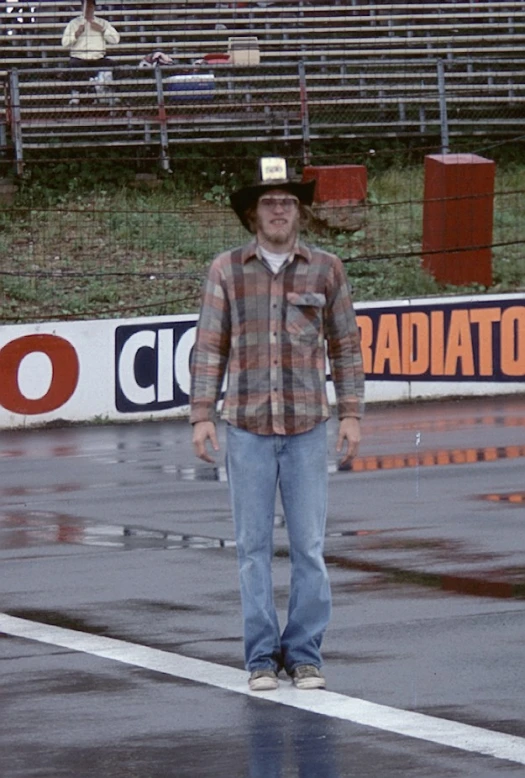 a man wearing a cowboy hat standing in the rain