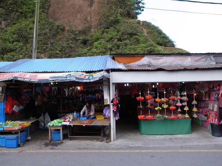 some stalls selling various items by the side of a road