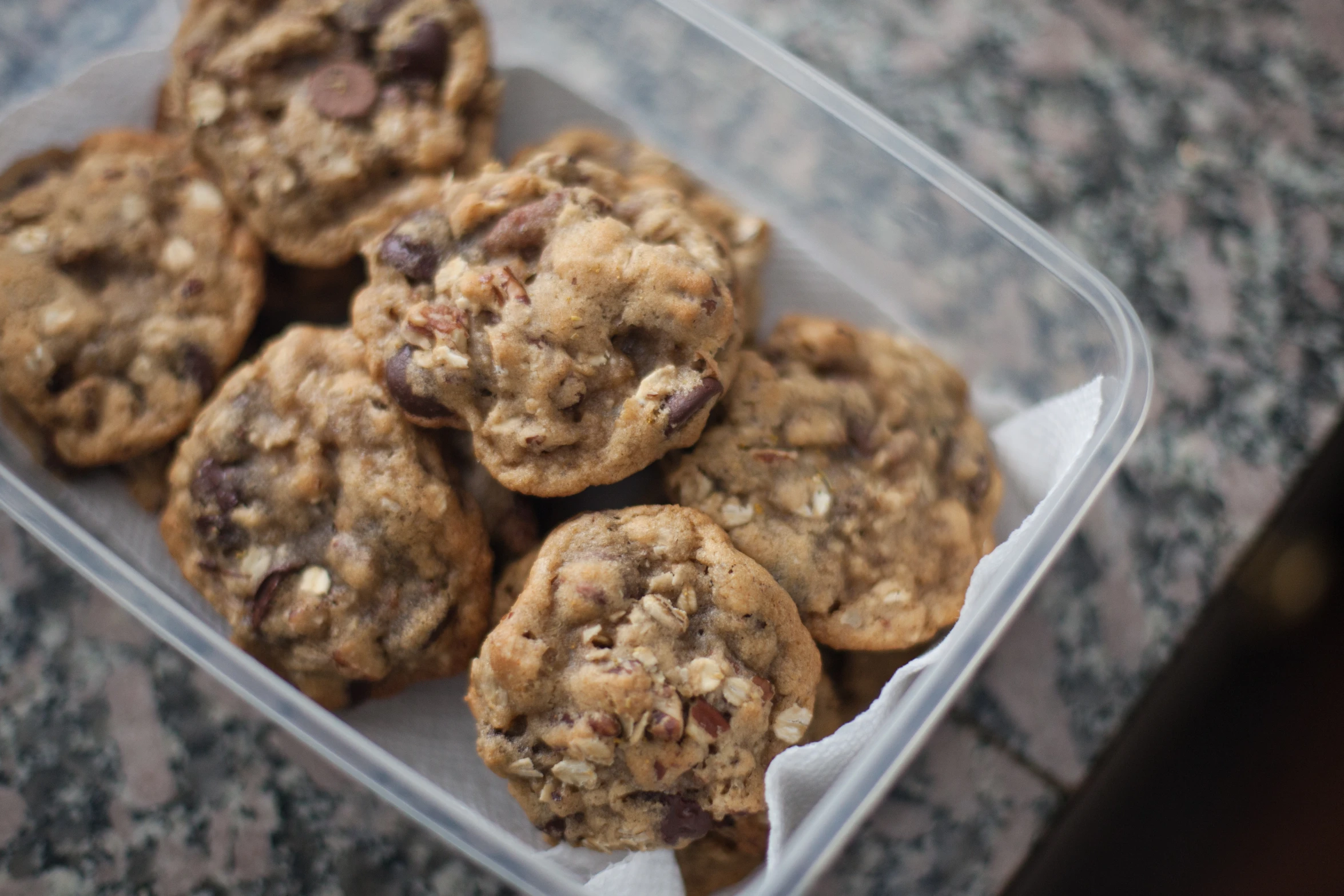 a plastic container filled with cookies on top of a counter