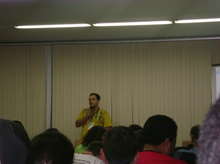 a man standing in front of a crowd speaking