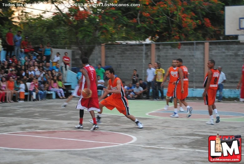 some boys playing basketball in a public court
