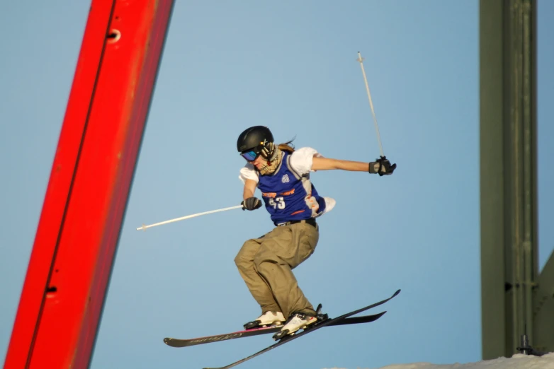 man doing an aerial trick on skies over a course