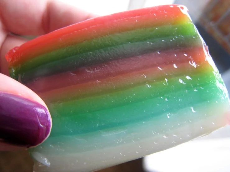 a pinky fingernail holding onto some candy