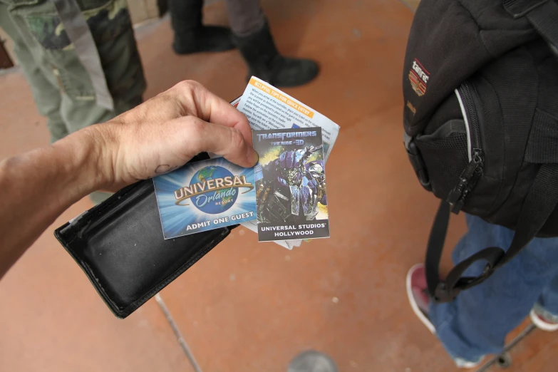 a person with a hand holding a nintendo game card
