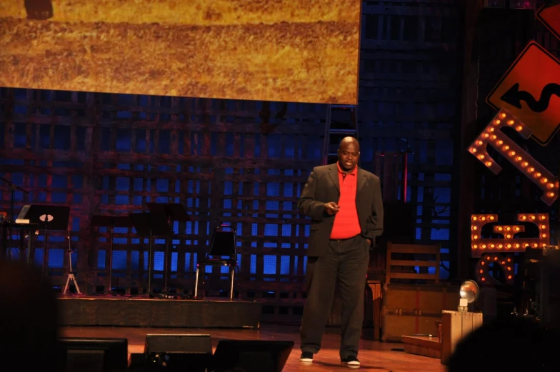 a man is standing on stage at night in front of lights