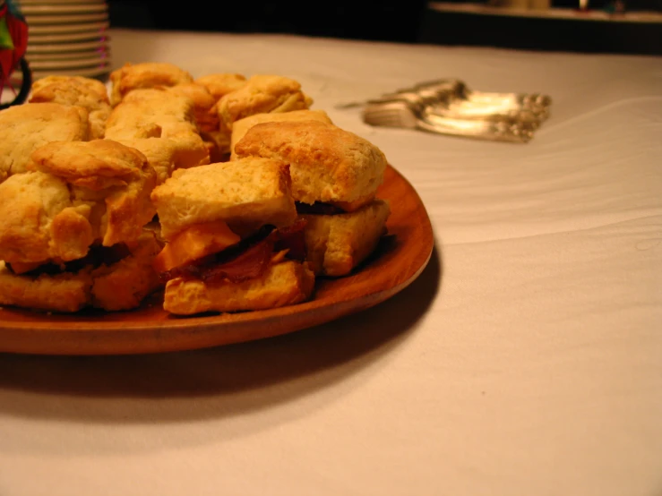 a wooden bowl filled with small pastries sitting on top of a table