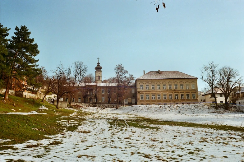 there is a snow covered field outside an old building