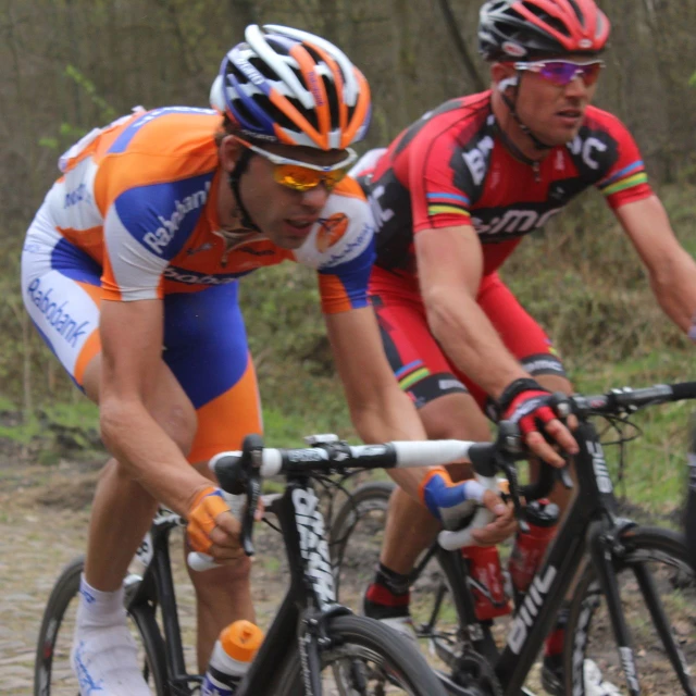 two men racing on their bicycles in the rain