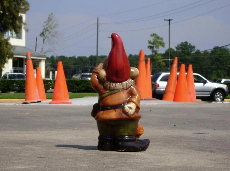 a statue of a large mushroom with a red hat in the middle of an intersection