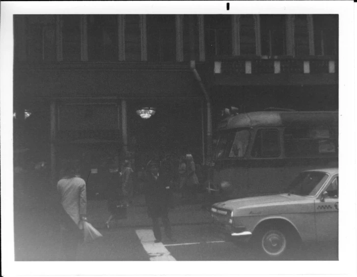 several people standing on the side of a street