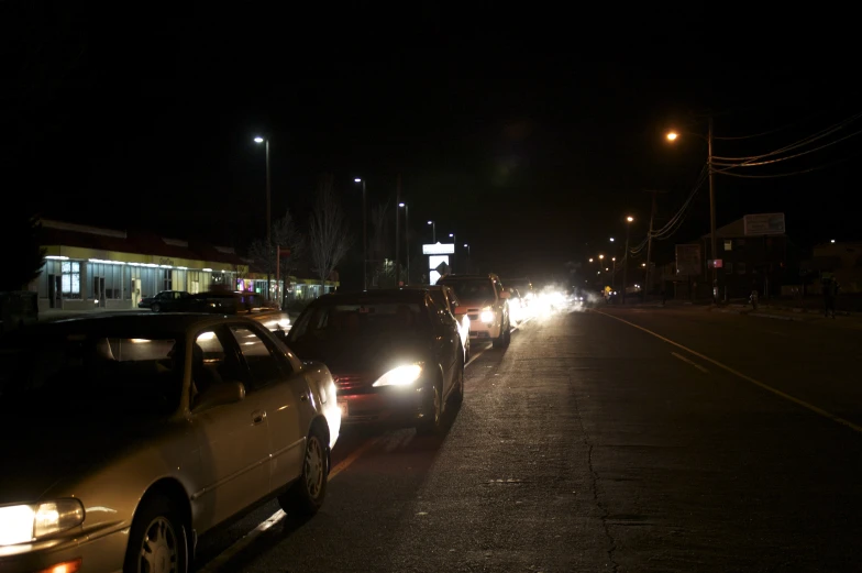 a long line of parked cars along the side of the road