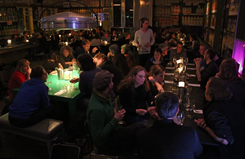 a room with people sitting down at different tables