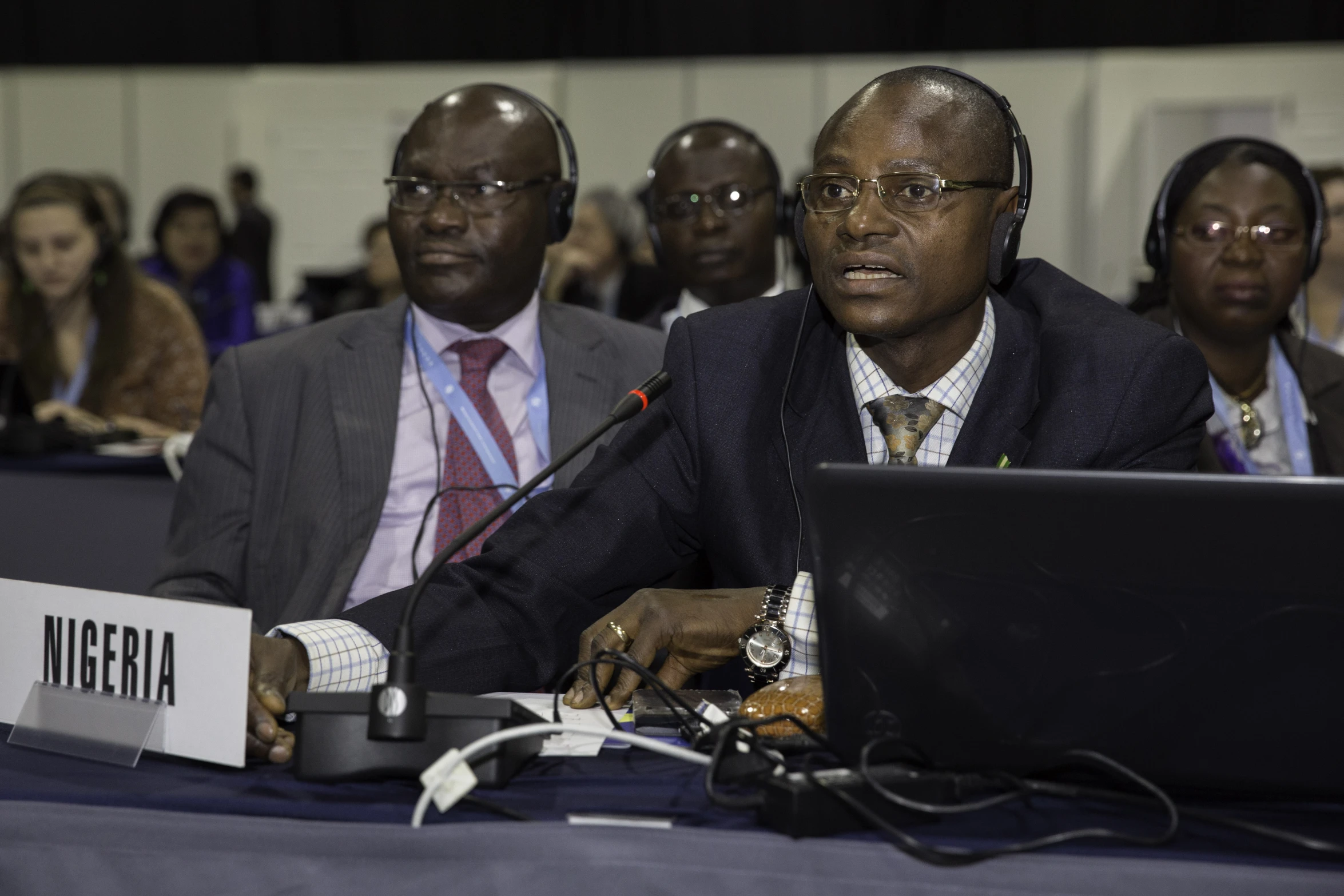 four black men with headset and two laptops