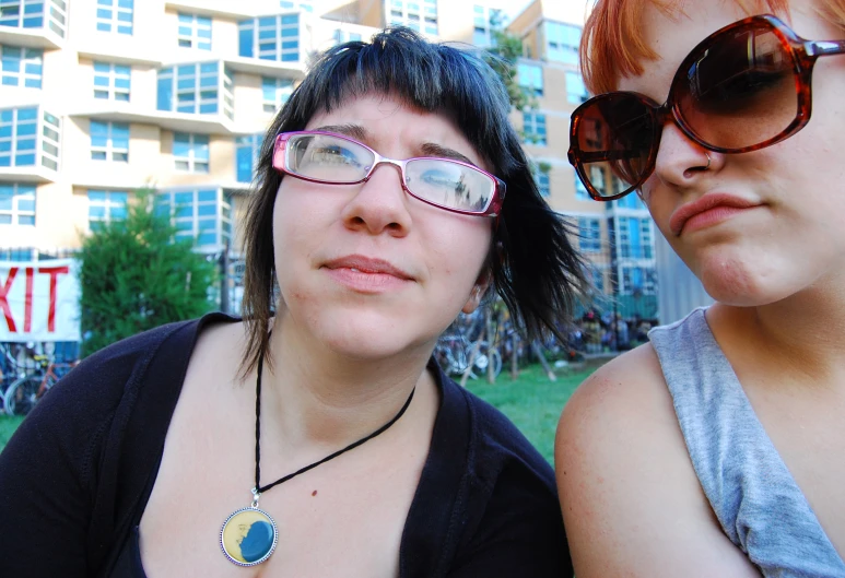 two woman wearing glasses are posing for the camera
