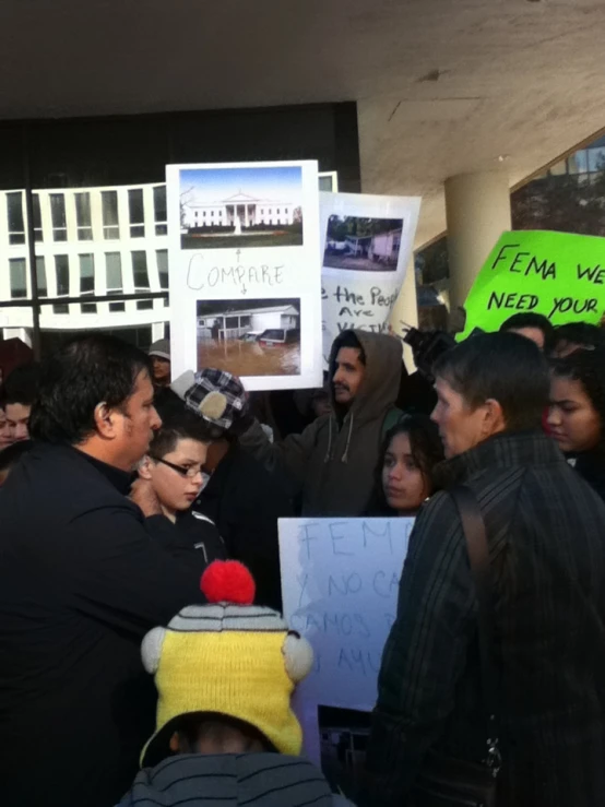 people holding up posters and signs while waiting to meet