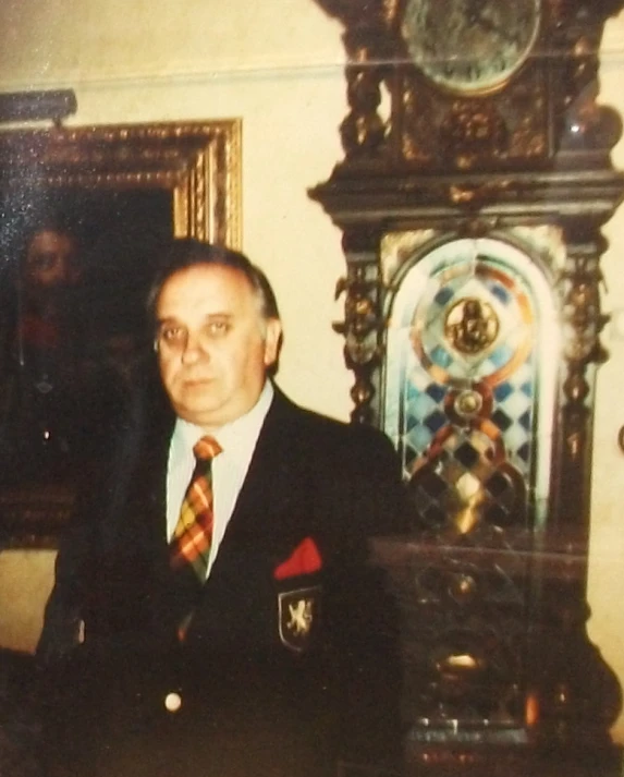 a man in a suit standing next to a grandfather clock