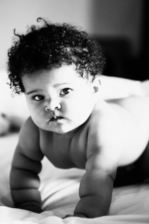 a small baby lying on a white bed