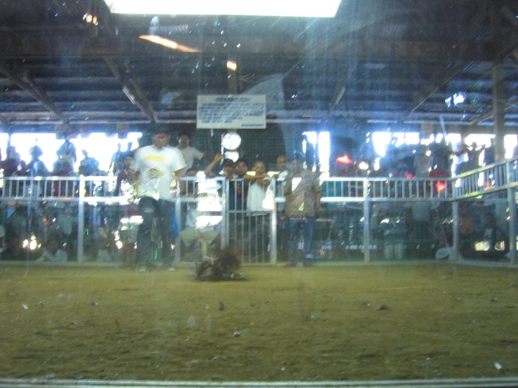 a crowd is standing by the gate while people are standing