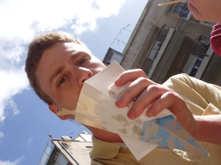 the young man is drinking from an empty card