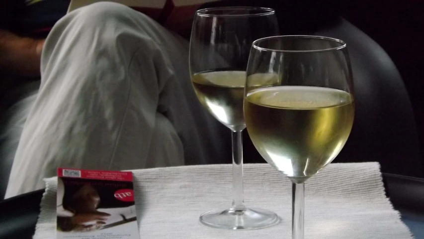 two champagne glasses on a table with the book on the side