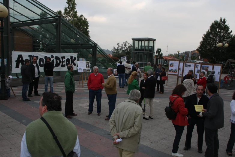 a group of people standing in a street with signs and posters