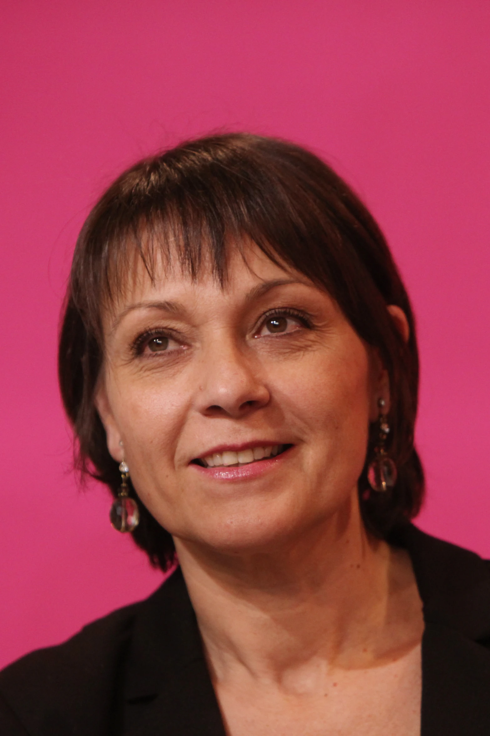 woman wearing earrings with pink background