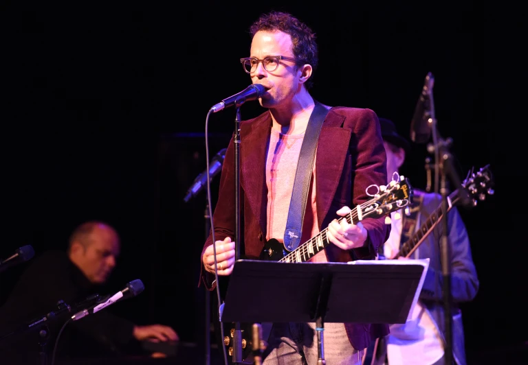 an image of a man playing guitar on stage