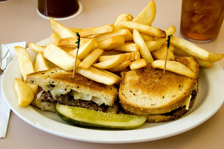 a sandwich, pickle slices, and some fries