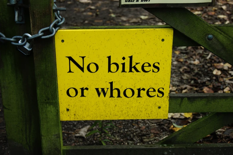 yellow sign with black lettering and the words no bikes or whokes on it