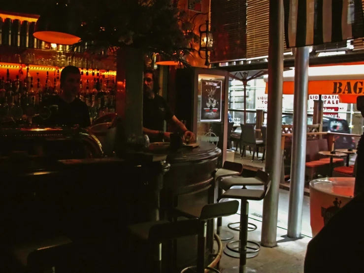 a man sitting at a bar that has stools and a piano