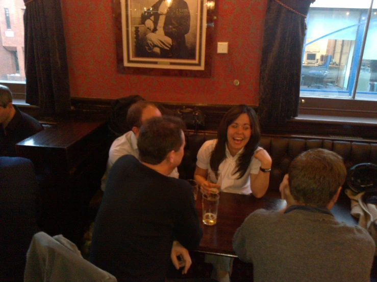 people sitting at a table talking and laughing